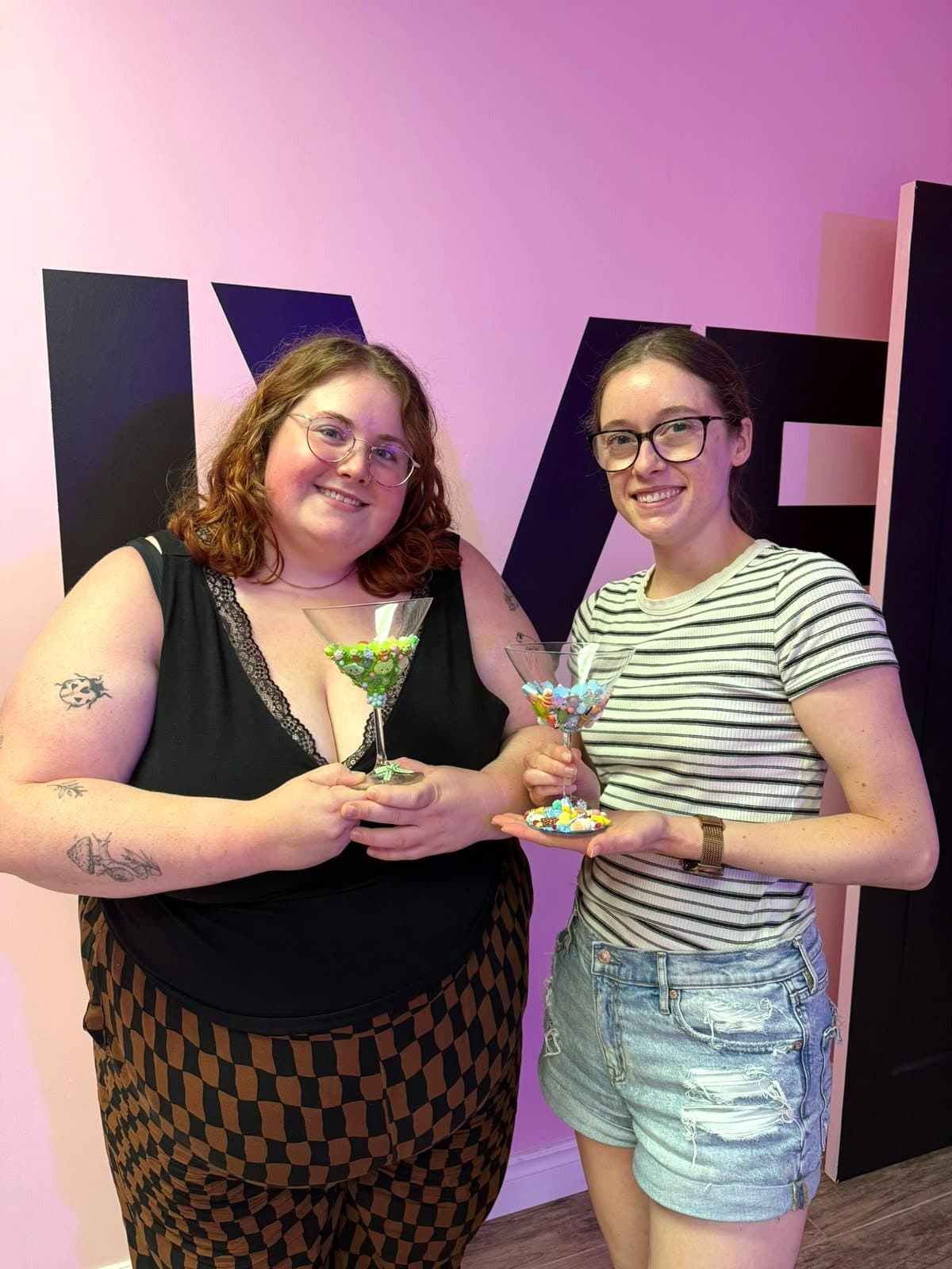 Two guests holding up their finished charm glasses